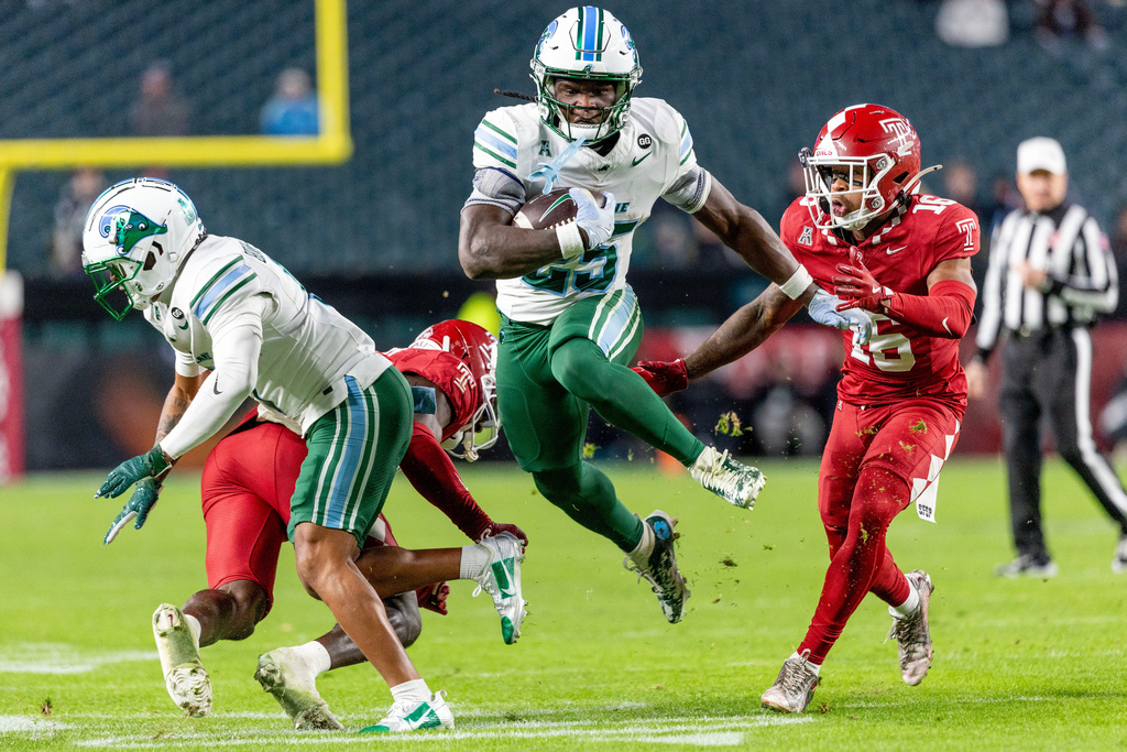 Tulane running back Jamauri McClure (25) leaps past Temple safety Pooh Lawton (16) during the second half of an NCAA college football game, Saturday, Nov. 22, 2025, in Philadelphia. (AP Photo/Laurence Kesterson)