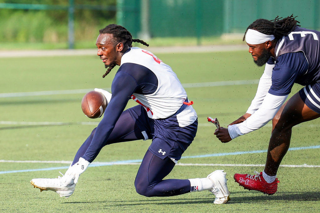 In this image provided by USA Football, Laval Davis, left, has his flag grabbed by a teammate during flag football practice for the United States national team in Charlotte, N.C. (Lester Barnes/USA Football via AP)
