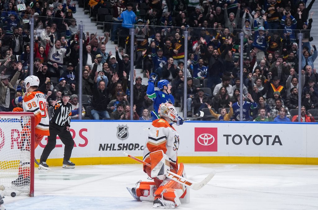 Vancouver Canucks' Drew O'Connor, back, celebrates his goal against Anaheim Ducks goalie Lukas Dostal during the third period of an NHL hockey game, in Vancouver, on Tuesday, March 24, 2026. (Darryl Dyck/The Canadian Press via AP)