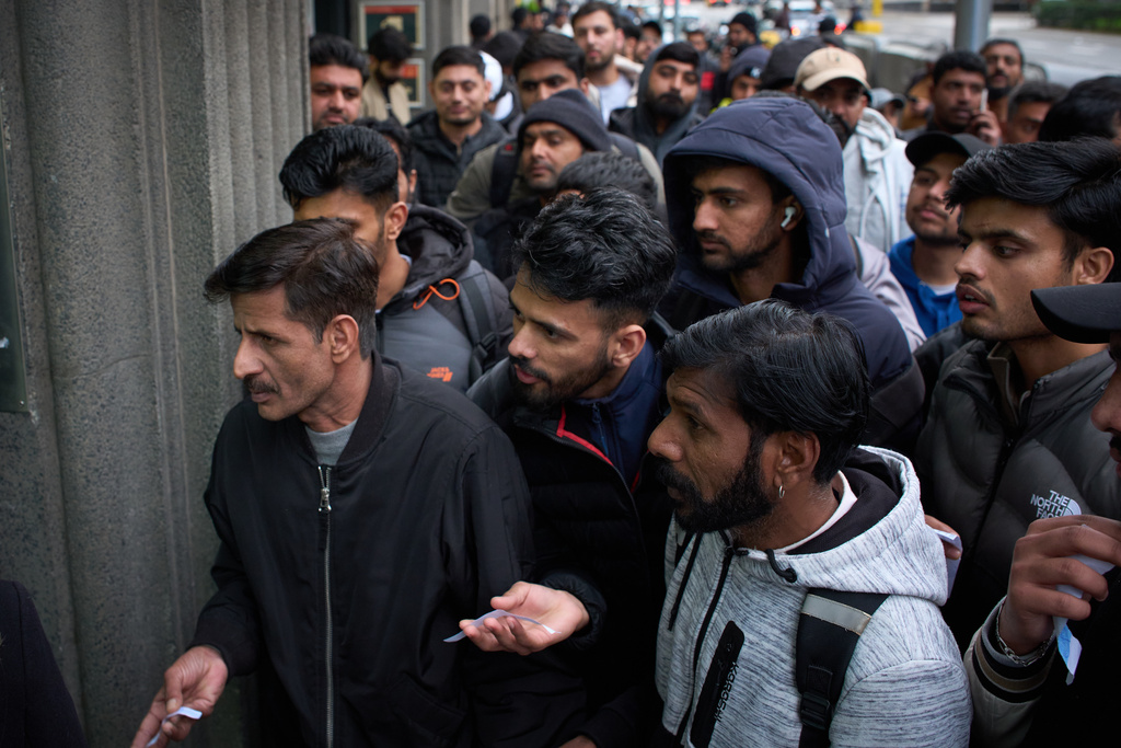 A crowd of Pakistanis gathers at the entrance of the Pakistani consulate in Barcelona, Spain, Thursday, Jan. 29, 2026, following the Spanish government's decision to grant residency and work permits to potentially hundreds of thousands of immigrants. (AP Photo/Emilio Morenatti)