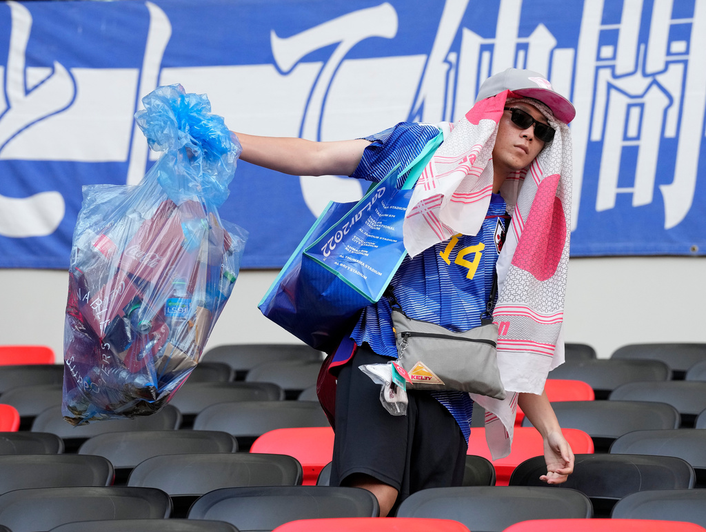 FILE - Japan's supporters clean their seats after losing the World Cup, group E soccer match between Japan and Costa Rica, at the Ahmad Bin Ali Stadium in Al Rayyan , Qatar, on Nov. 27, 2022. (AP Photo/Eugene Hoshiko, File)