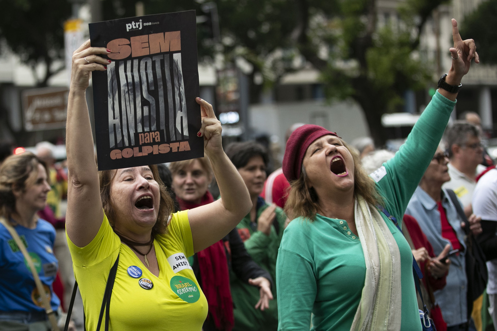 A demonstrator holds a sign of former Brazilian President Jair Bolsonaro and the reads in Portuguese, "No amnesty for coup plotters" during a march against economic inequality, on Independence Day in Rio de Janeiro, Sunday, Sept. 7, 2025. (AP Photo/Bruna Prado)