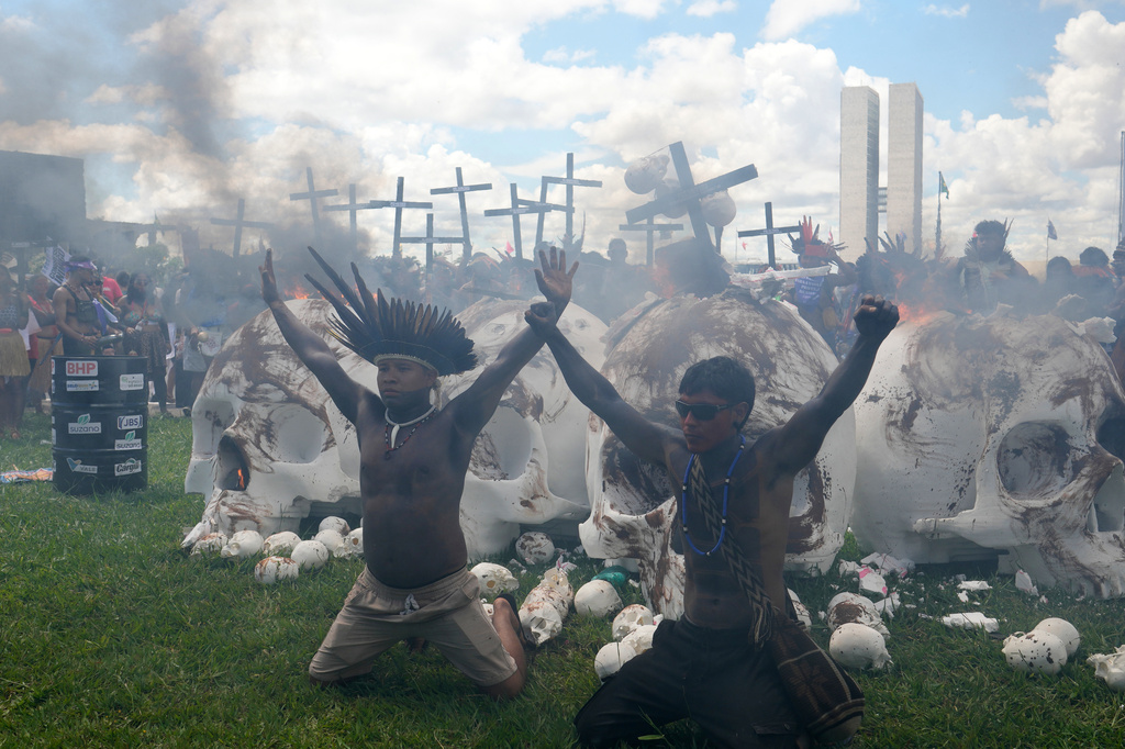 Indigenous protesters set fire to skull sculptures representing lawmakers to protest Congress during the annual "Acampamento Terra Livre," or Free Land Encampment, Brazil's largest annual Indigenous mobilization that focuses on land rights and environmental protection, in Brasilia, Brazil, Tuesday, April 7, 2026. (AP Photo/Eraldo Peres)