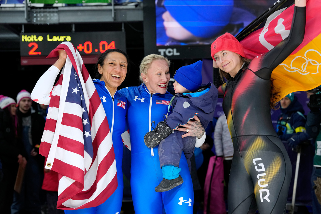 From let, United States' gold medalist Elana Meyers Taylor, United States' bronze medalist Kaillie Armbruster Humphries and Germany's silver medalist Laura Nolte celebrate at the finish after the women's monobob competition at the 2026 Winter Olympics, in Cortina d'Ampezzo, Italy, Monday, Feb. 16, 2026. (AP Photo/Alessandra Tarantino)