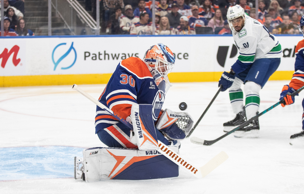 Edmonton Oilers' goalie Calvin Pickard (30) makes the save as Vancouver Canucks' Evander Kane (91) looks for the rebound during the third period of an NHL game in Edmonton on Saturday, Oct. 11, 2025. (Jason Franson/The Canadian Press via AP)