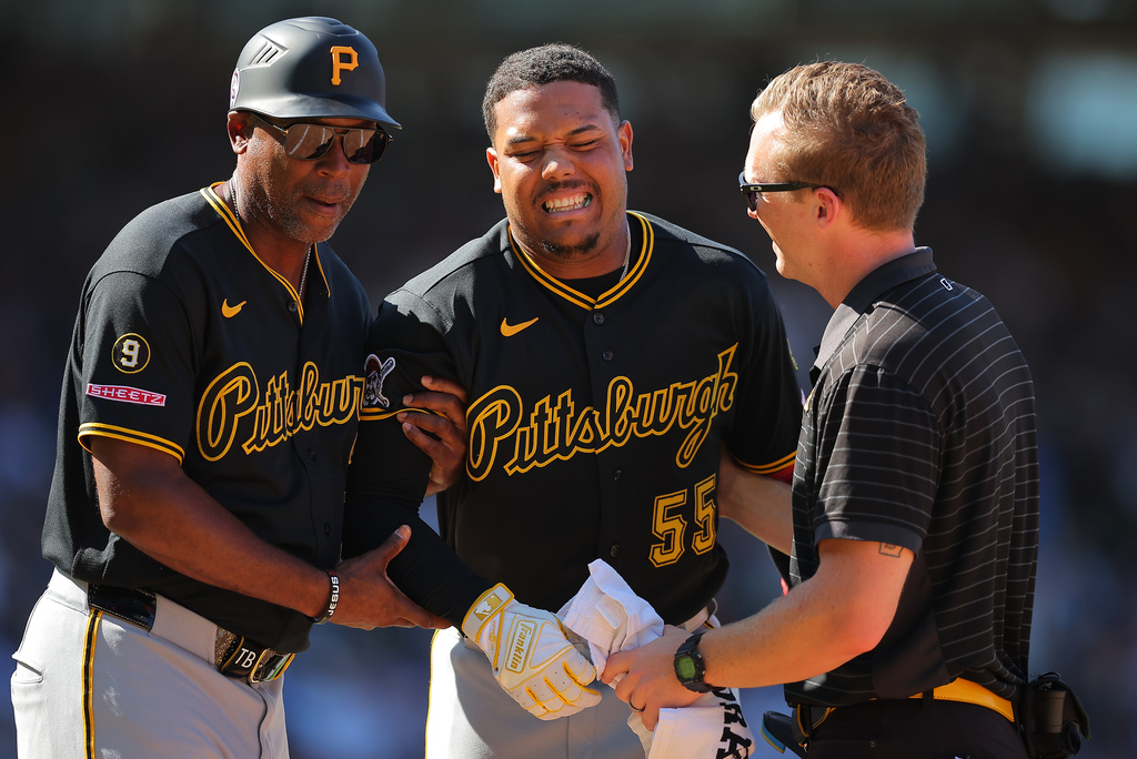 Pittsburgh Pirates' Esmerlyn Valdez, center, is helped off the field by first base coach Tarrik Brock, left, and a trainer during the sixth inning of a baseball game against the Chicago Cubs, Friday, Sept. 11, 2026, in Chicago. (AP Photo/Melissa Tamez)
