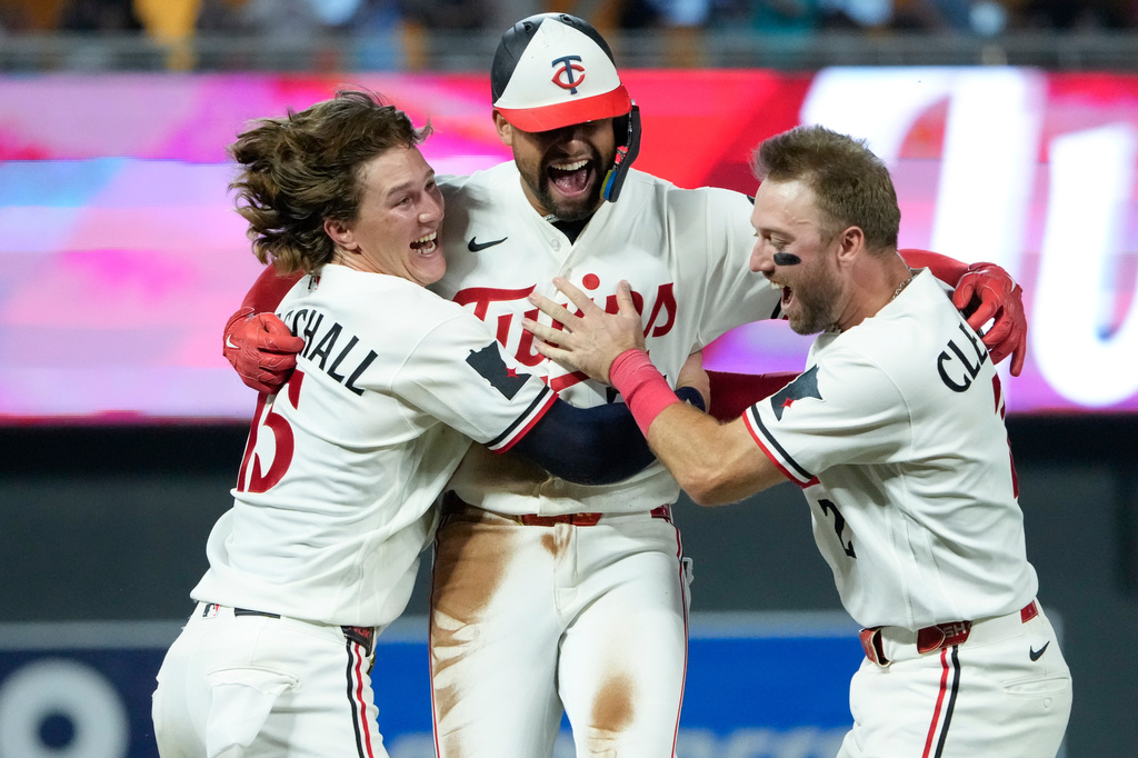Minnesota Twins' Royce Lewis, center, celebrates with Luke Keaschall, left, and Kody Clemens after hitting an RBI triple walk-off scoring Victor Caratini and Brooks Lee in the ninth inning of a baseball game against the Kansas City Royals, Tuesday, July 28, 2026, in Minneapolis. (AP Photo/Joseph Scheller)