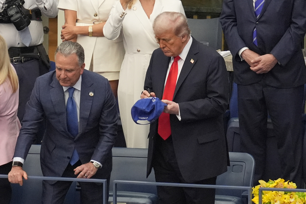 President Donald Trump signs a hat during the US Open tennis men's singles final Sunday, Sept. 7, 2025, in Flushing, N.Y. (AP Photo/Manuel Balce Ceneta)