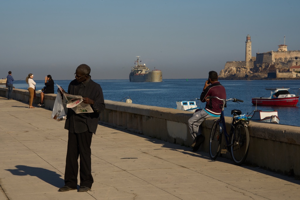 A man reads a newspaper at the Havana Bay where the Mexican Navy ship Isla Holbox, carrying aid according to the Mexican government, arrives in Cuba, Thursday, Feb. 12, 2026. (AP Photo/Ramon Espinosa)