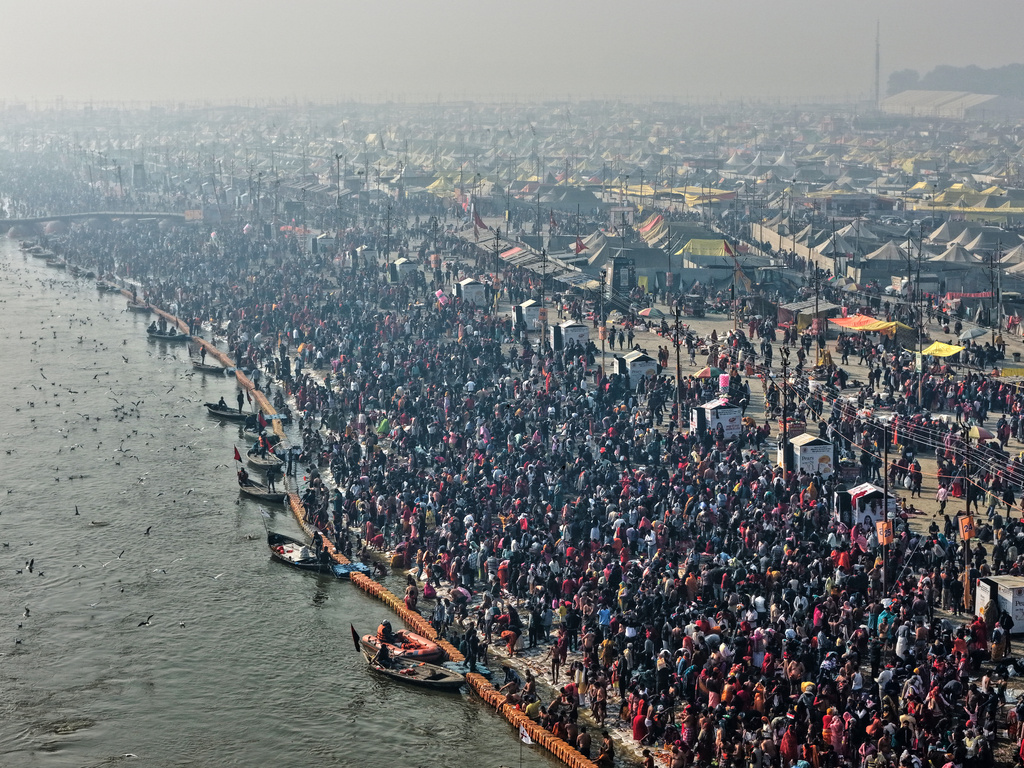 Devotees arrive for a holy dip on Mauni Amavasya, a divine occasion in Hindu religious practice followed for honoring ancestors or forefathers, at the Sangam, the confluence of the Ganges, the Yamuna and the mythical Saraswati rivers, during the annual month long Hindu religious fair "Magh Mela" in Prayagraj, India, Sunday, Jan. 18, 2026. (AP Photo/Rajesh Kumar Singh)
