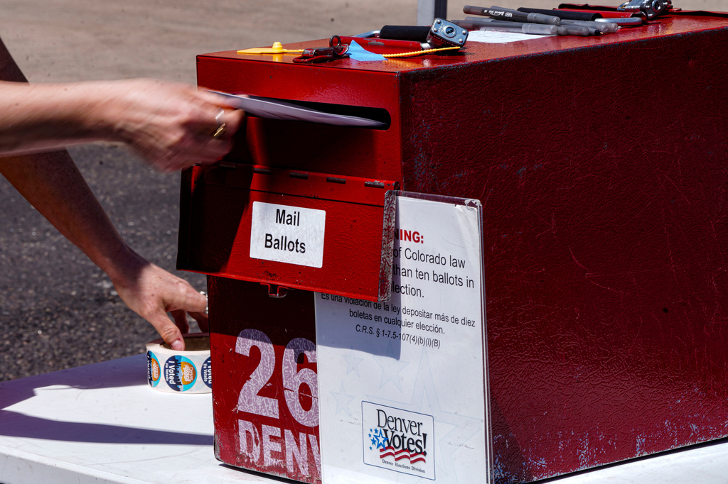 Erin Ludlam places a ballot in a drop-off box for the Democratic primaries at Blair-Caldwell Library, Tuesday, June 30, 2026, in Denver. (AP Photo/Rebecca Slezak)