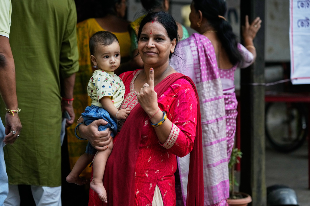 A woman shows the indelible ink mark on her index finger after casting her vote at a polling center during the state election in Guwahati, India, Thursday, April 9, 2026. (AP Photo/Anupam Nath)