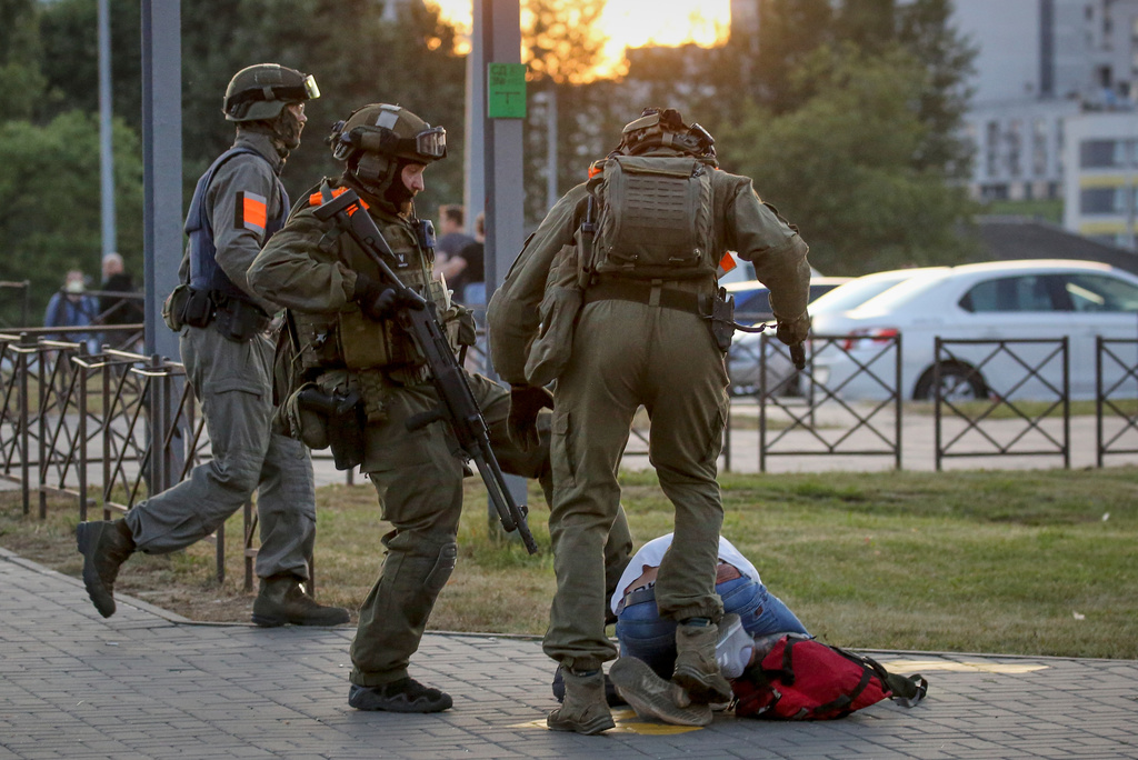 FILE - Police officers kick a demonstrator during a mass protest following presidential election in Minsk, Belarus, Monday, Aug. 10, 2020. (AP Photo, File)