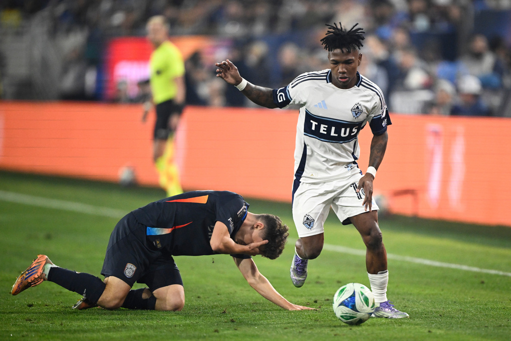 Vancouver Whitecaps defender Édier Ocampo (18) breaks away from San Diego FC defender Luca Bombino during the first half of an MLS Western Conference final soccer match, Saturday, Nov. 29, 2025, in San Diego. (AP Photo/Denis Poroy)