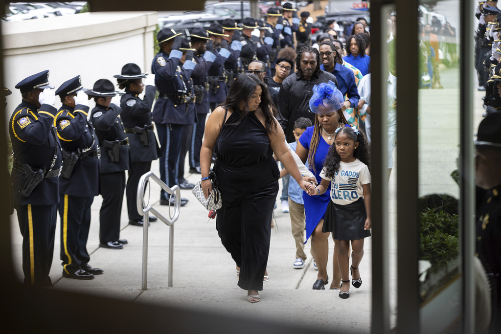 Family members, including DeKalb County Police Officer David Rose's daughter, right, arrive at First Baptist Church Atlanta in Atlanta for his funeral Friday, Aug. 22, 2025. Rose was killed while responding to a shooting at the CDC. (Arvin Temkar/Atlanta Journal-Constitution via AP)