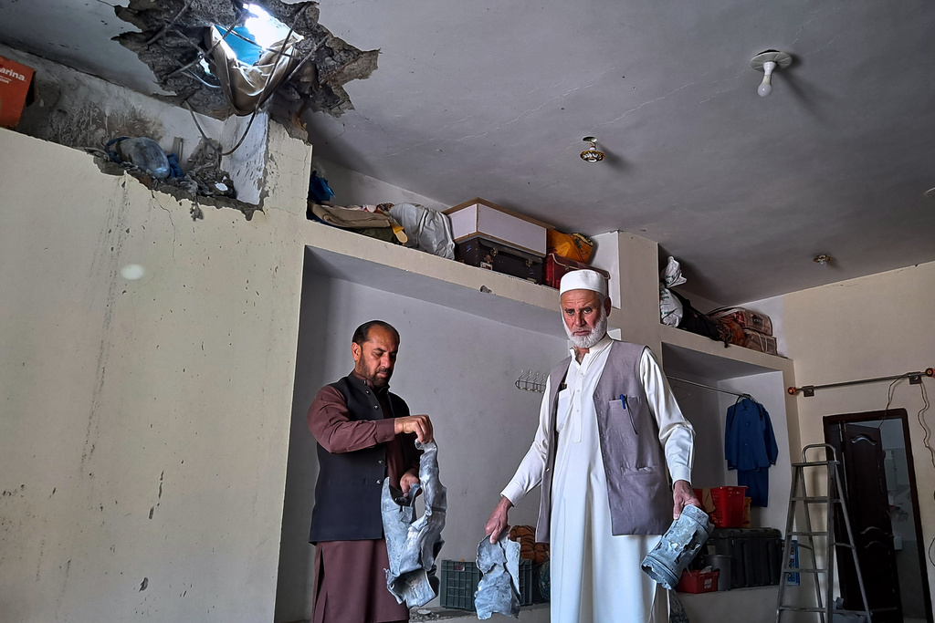 Local residents remove pieces of mortar shell fired by Afghan forces, which damaged their house at a village in Khyber, a district of Pakistan's Khyber Pakhtunkhwa province bordering with Afghanistan, Thursday, March 5, 2026. (AP Photo/S.B. Shah)