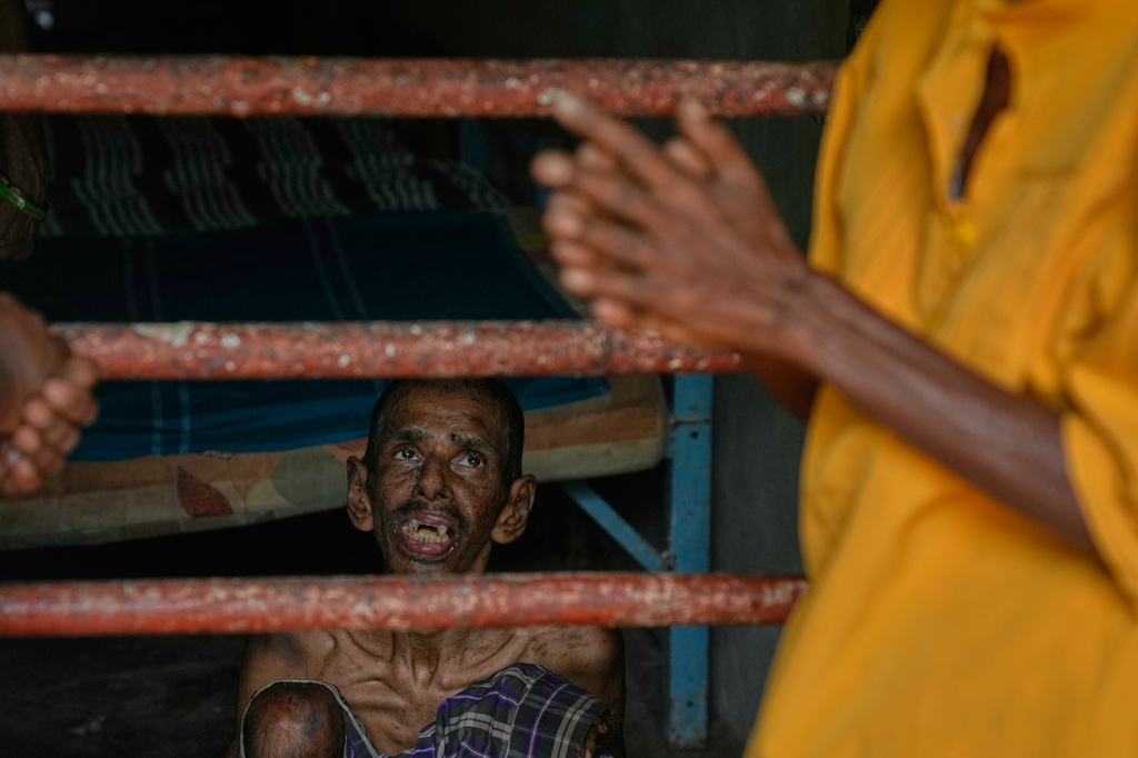 A resident looks at his family members as he sits inside his dormitory at a nursing home in Anguruwatota, Sri Lanka, Friday, June 5, 2026. (AP Photo/Eranga Jayawardena)