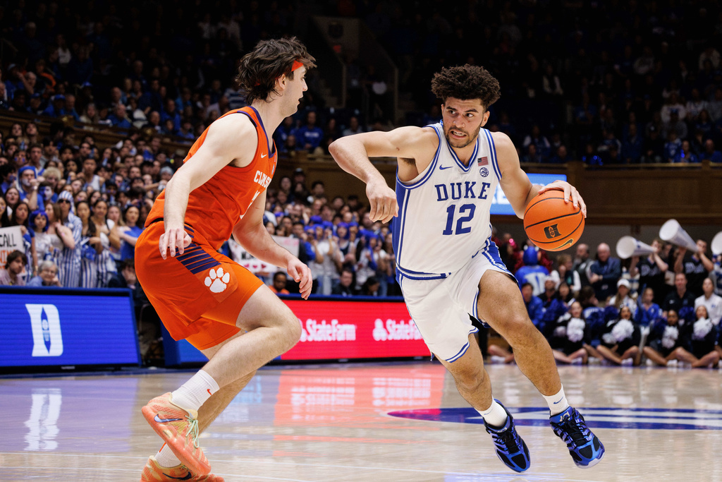 Duke's Cameron Boozer (12) drives against Clemson's Carter Welling, left, during the second half of an NCAA college basketball game in Durham, N.C., Saturday, Feb. 14, 2026. (AP Photo/Ben McKeown)