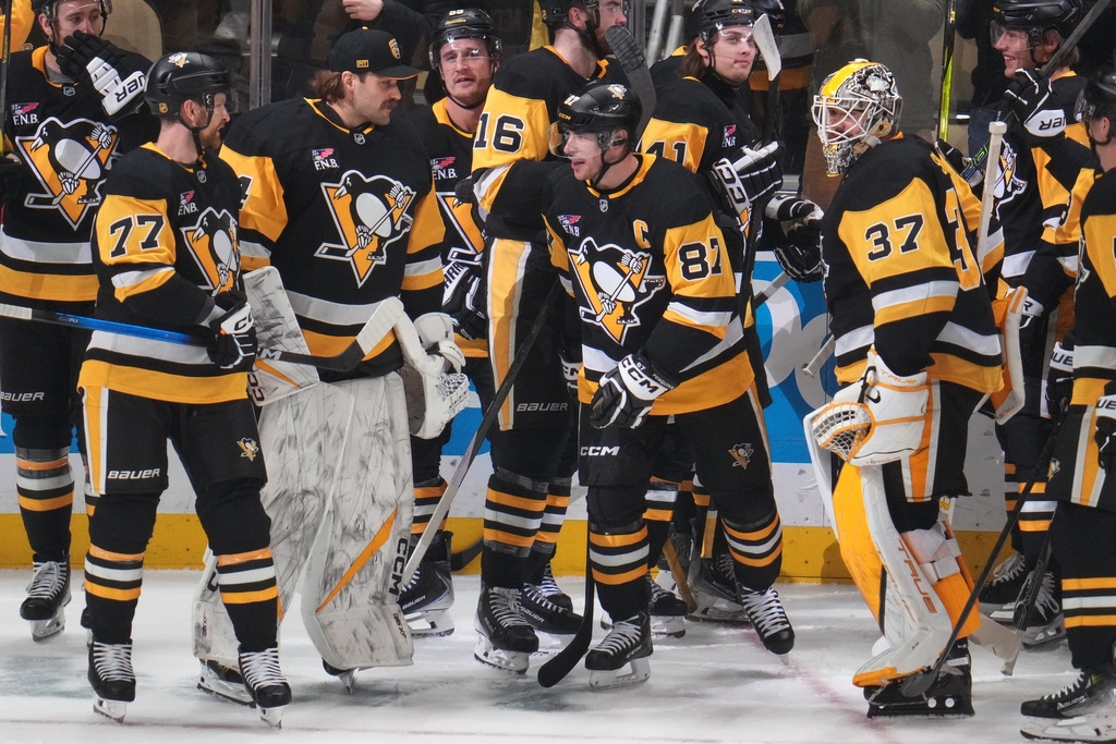 Pittsburgh Penguins' Sidney Crosby (87) skates back to the bench after celebrating with teammates after taking over from former Penguins' Mario Lemieux, as the Penguins all-time points leader during the first period of an NHL hockey game against the Montréal Canadiens in Pittsburgh, Sunday, Dec. 21, 2025. (AP Photo/Gene J. Puskar)