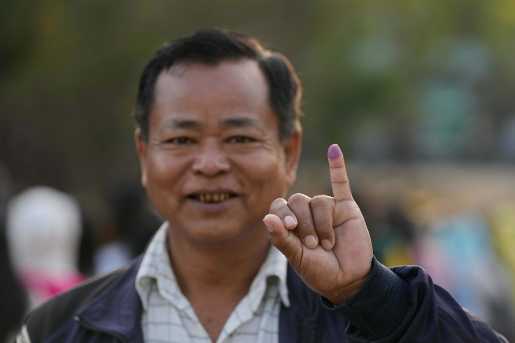 A voter holds up his finger, marked with ink to indicate he voted, at a polling station in Naypyitaw, Myanmar, Sunday, Dec. 28, 2025. (AP Photo/Aung Shine Oo)