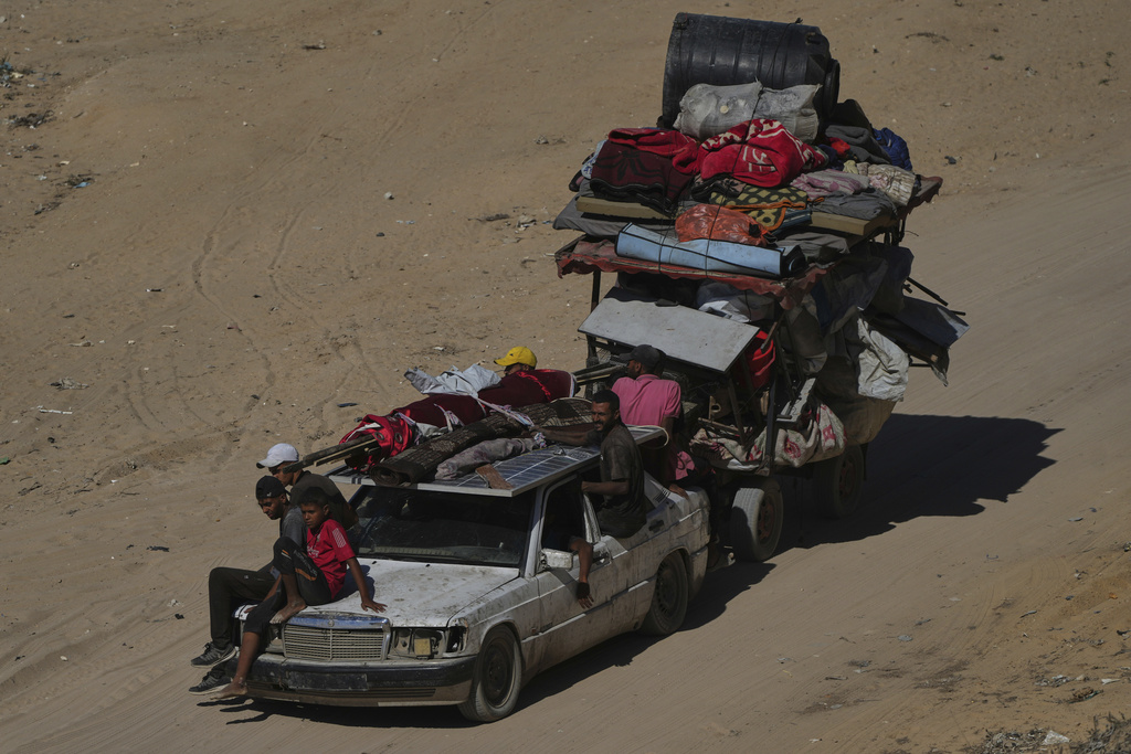 Displaced Palestinians fleeing northern Gaza carry their belongings along the coastal road toward southern Gaza, Wednesday, Sept. 10, 2025, after the Israeli army issued evacuation orders from Gaza City. (AP Photo/Abdel Kareem Hana)