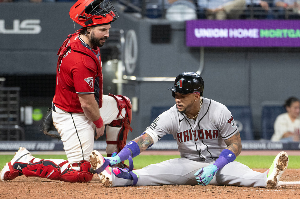 Cleveland Guardians' Austin Hedges, left, checks with Arizona Diamondbacks' Ketel Marte, right, after he was hit by a pitch from Hunter Gaddis during the seventh inning of a baseball game, Saturday, Aug. 1, 2026, in Cleveland. (AP Photo/Phil Long)