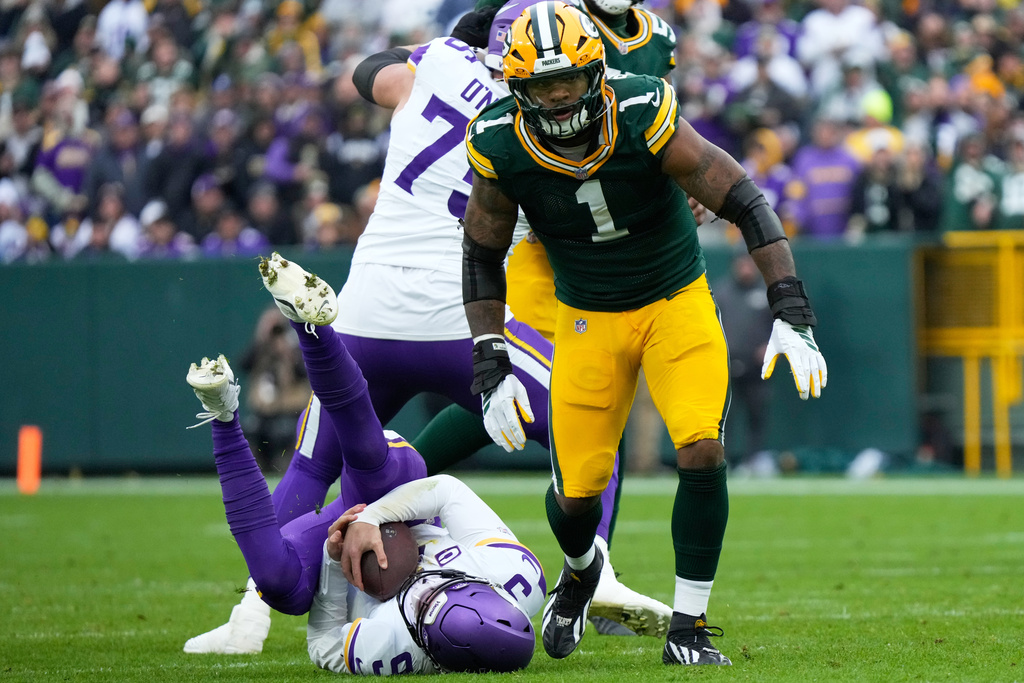 Minnesota Vikings quarterback J.J. McCarthy (9) lays on the ground after being sacked by Green Bay Packers defensive end Micah Parsons (1) during the second half of an NFL football game Sunday, Nov. 23, 2025, in Green Bay, Wis. (AP Photo/Morry Gash)