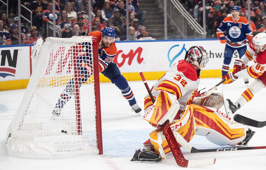Edmonton Oilers' Leon Draisaitl (29) scores his 400th career goal against Calgary Flames goalie Dustin Wolf (32) during second period NHL action, in Edmonton on Wednesday, Oct. 8, 2025. (Jason Franson/The Canadian Press via AP)