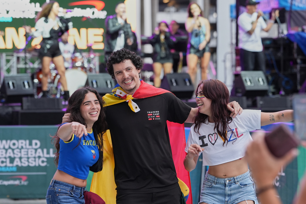 Venezuela fans pose for photos before the championship game of the World Baseball Classic against the United States, Tuesday, March 17, 2026, in Miami. (AP Photo/Lynne Sladky)