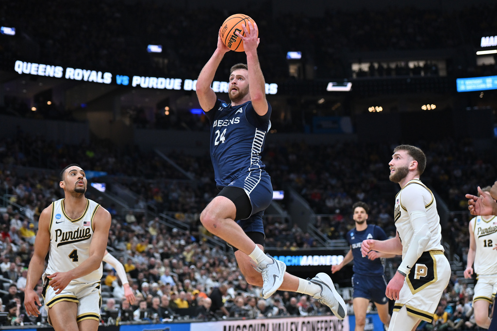 Queens University's Yoav Berman (24) heads to the basket as Purdue's Trey Kaufman-Renn (4) and Braden Smith, right, defend during the second half in the first round of the NCAA college basketball tournament, Friday, March 20, 2026, in St. Louis. (AP Photo/Ali Overstreet)