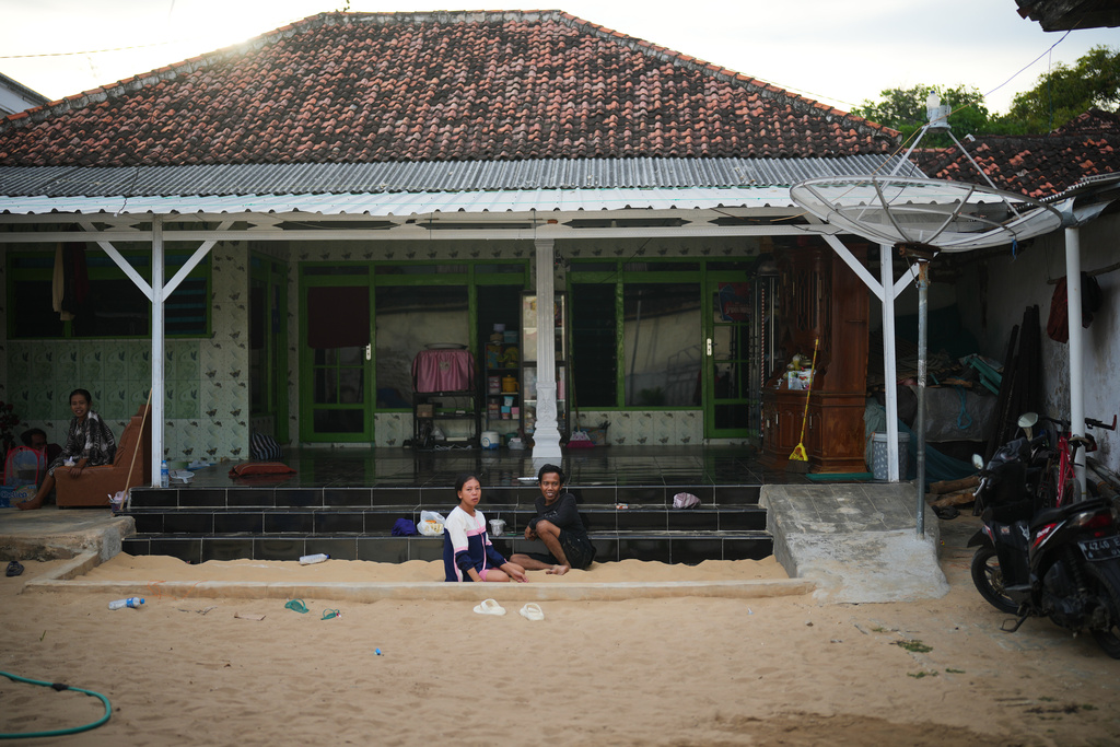 People spend their afternoon in a sandpit which is available in almost every house in Legung Timur village in Sumenep on Madura Island, Indonesia, Tuesday, Sept. 9, 2025. (AP Photo/Dita Alangkara)