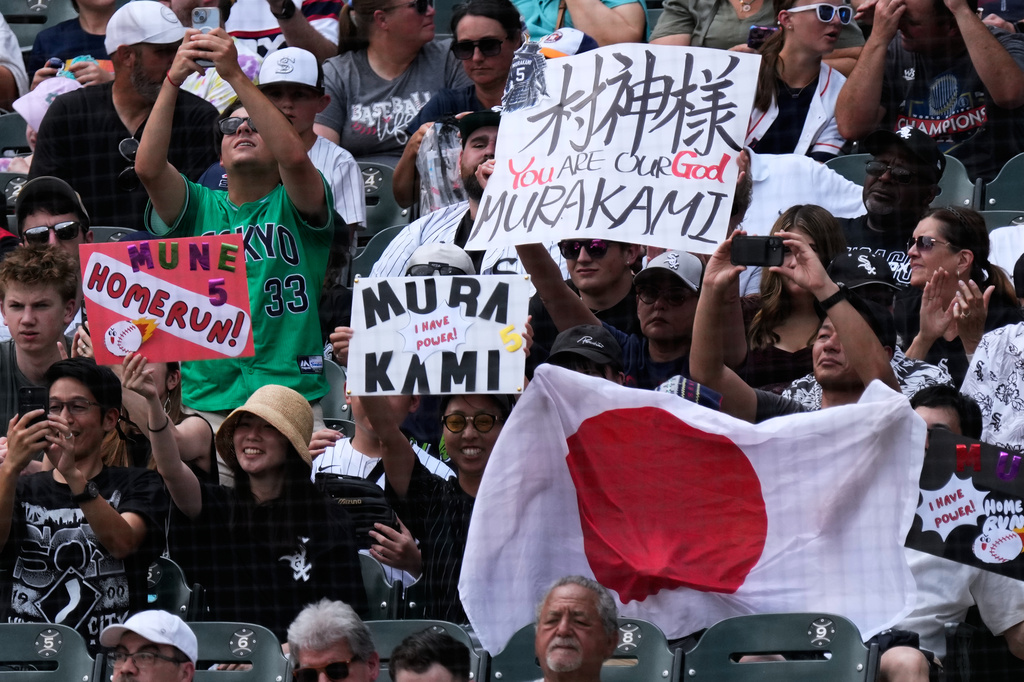 Fans of Chicago White Sox's Munetaka Murakami of Japan, hold signs and a Japanese flag during the first inning of a baseball game between the Houston Astros and the Chicago White Sox in Chicago, Sunday, July 26, 2026. (AP Photo/Nam Y. Huh)