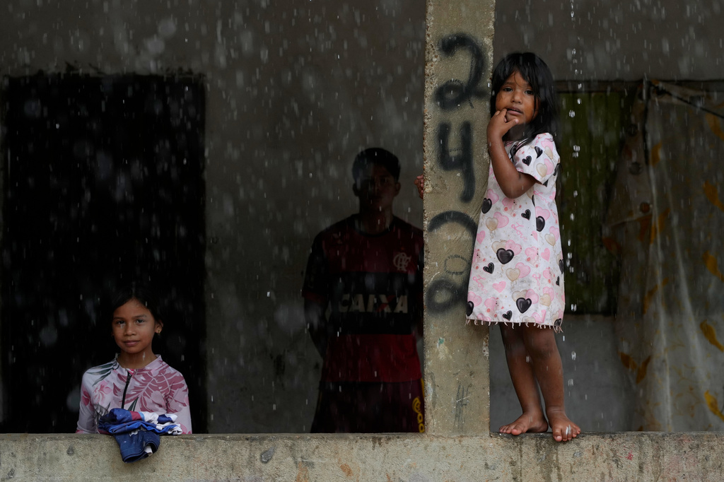 Children watch from the balcony of their house in an area known as Nova Conquista or New Conquest where families are building houses near the center of Oiapoque, Amapa state, Brazil, Tuesday, March 10, 2026. (AP Photo/Eraldo Peres)