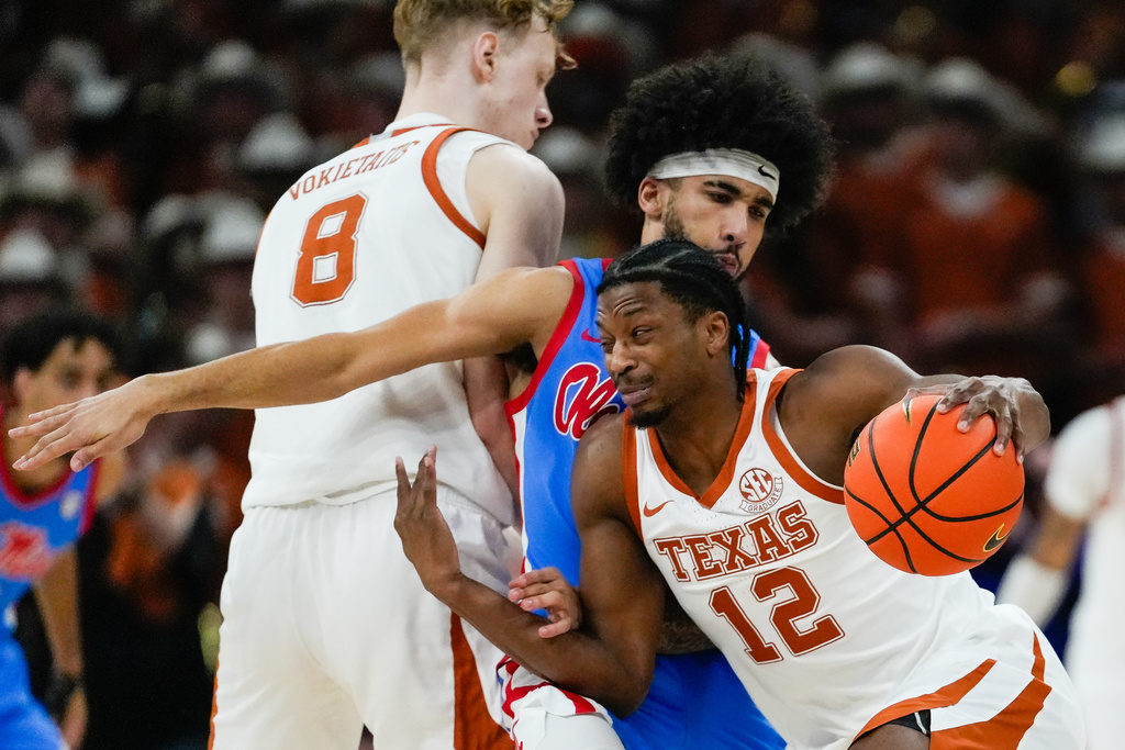 Texas guard Tramon Mark (12) pushes past the defense from Mississippi guard Kezza Giffa (13) during the first half of an during an NCAA college basketball game, Saturday, Feb. 7, 2026, in Austin, Texas. (Sara Diggins/Austin American-Statesman via AP)