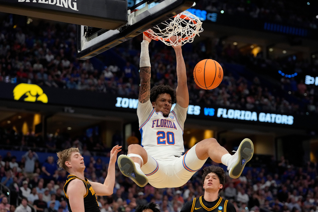 Florida guard Isaiah Brown (20) slam dunks over Iowa forward Cooper Koch and guard Isaia Howard during the second half in the second round of the NCAA college basketball tournament Sunday, March 22, 2026, in Tampa, Fla. (AP Photo/Chris O'Meara)