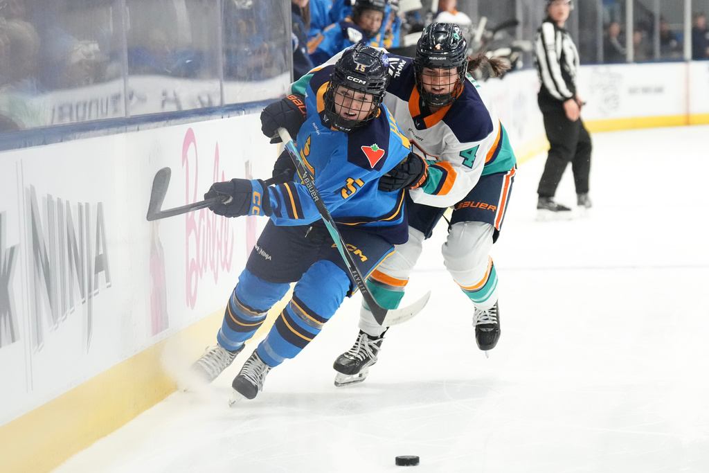 Toronto Sceptres' Savannah Harmon, left, competes for the puck with New York Sirens' Elle Hartje during first period PWHL hockey action, in Toronto, on Tuesday Jan. 6, 2026. (Chris Young/The Canadian Press via AP)
