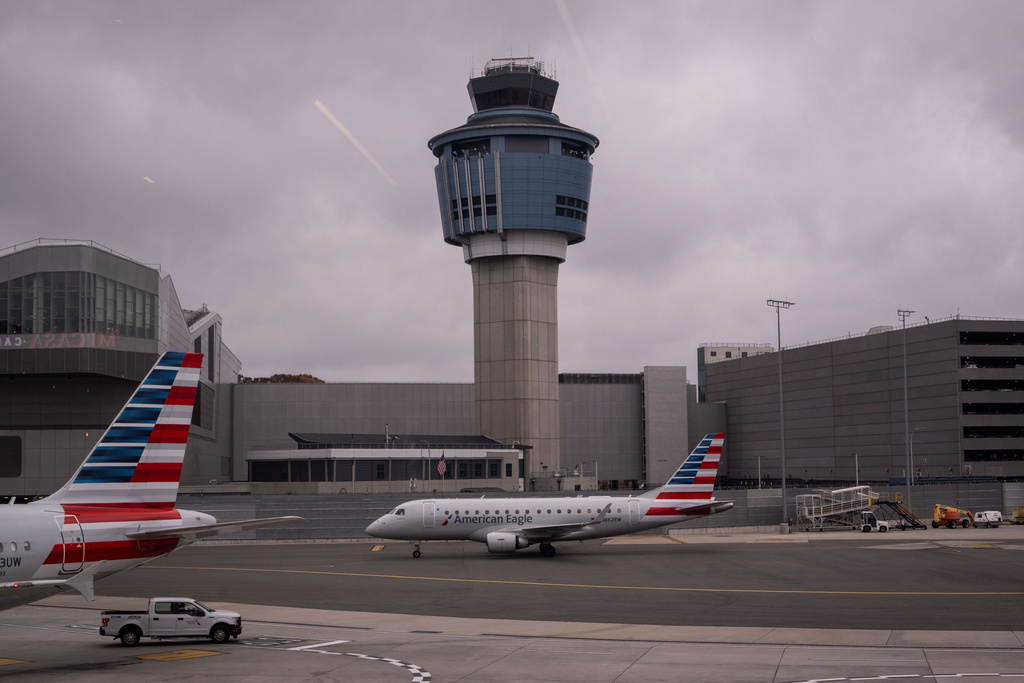An American Eagle plane moves past the FAA Air Traffic Control tower at LaGuardia Airport (LGA) in the Queens borough of New York, Sunday, Nov. 9, 2025. (AP Photo/Adam Gray)