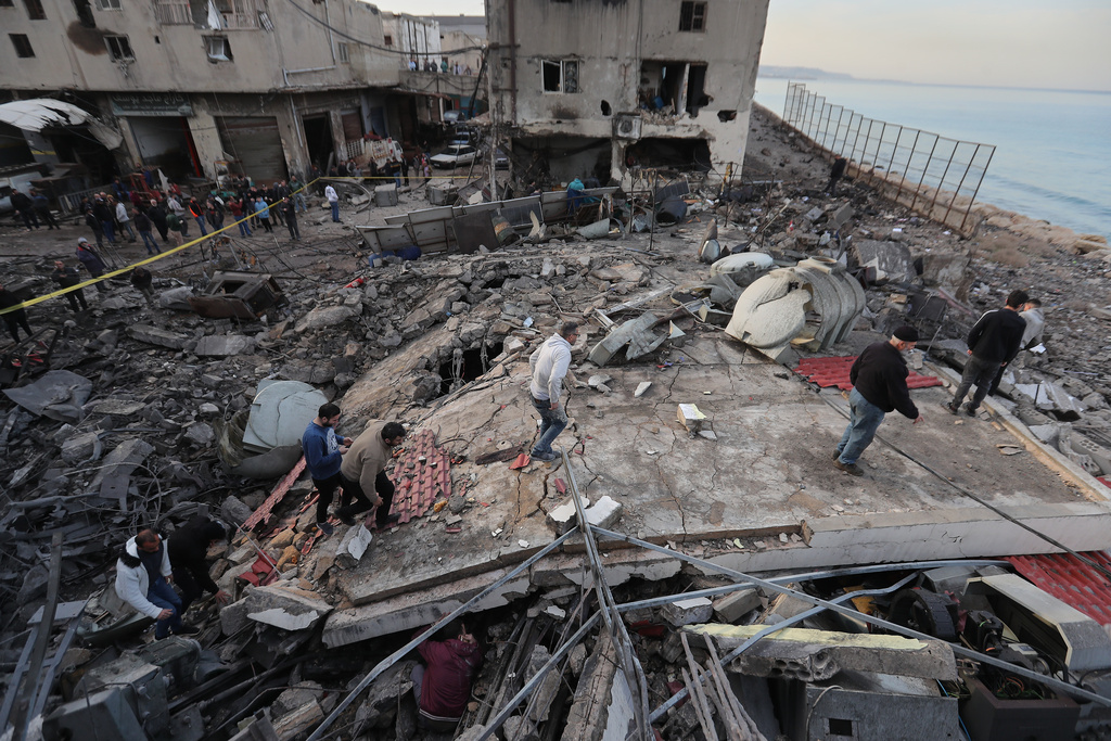 People check a destroyed building that was hit by an Israeli airstrike at a commercial district, in the southern port city of Sidon, Lebanon, Tuesday, Jan. 6, 2026. (AP Photo/Mohammed Zaatari)