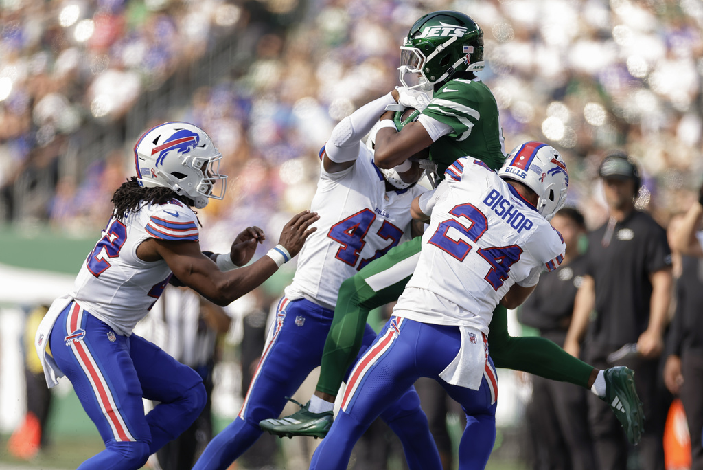 New York Jets wide receiver Garrett Wilson (5) is tackled and forced out of bounds by Buffalo Bills safety Cole Bishop (24) and cornerback Christian Benford (47) during the fourth quarter of an NFL football game, Sunday, Sept. 14, 2025, in East Rutherford, N.J. (AP Photo/Adam Hunger)