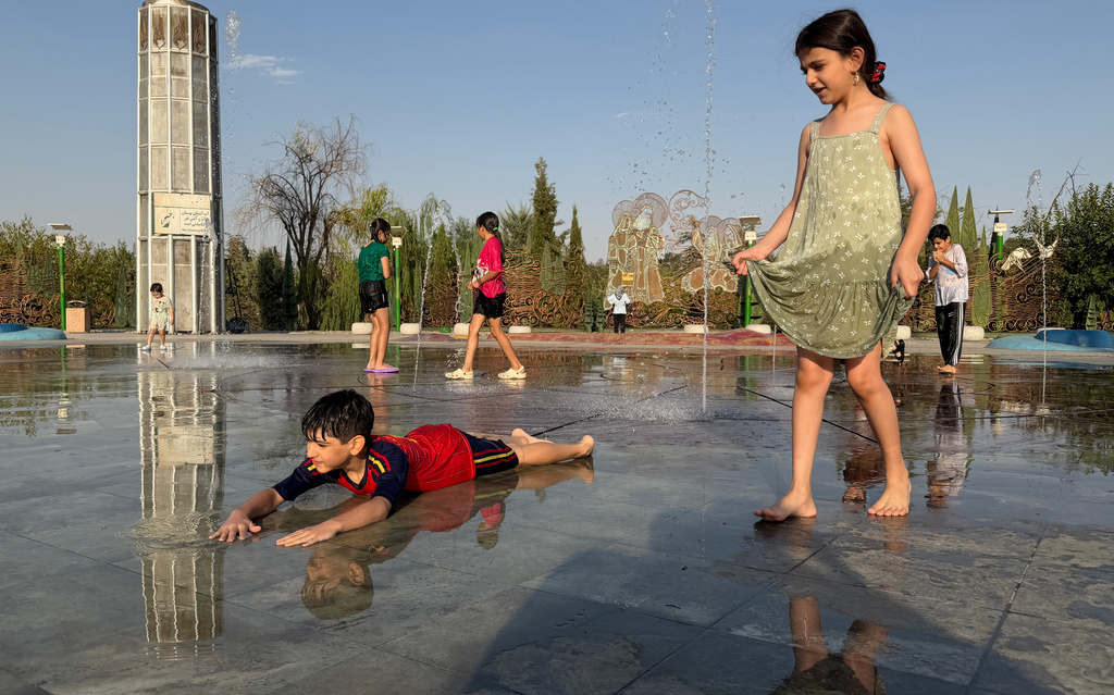 Children enjoy a water fountain at the Ebrahim (Abraham) Park, while temperature reaches 40 C (104 F) in Tehran, Iran, Thursday, Aug. 20, 2026. (AP Photo/Vahid Salemi)