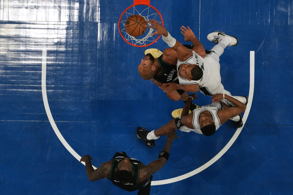 San Antonio Spurs forward Victor Wembanyama (1), right, scores against Minnesota Timberwolves center Rudy Gobert (27) during the first half of Game 4 of an NBA basketball second-round playoffs series, Sunday, May 10, 2026, in Minneapolis. (AP Photo/Abbie Parr)