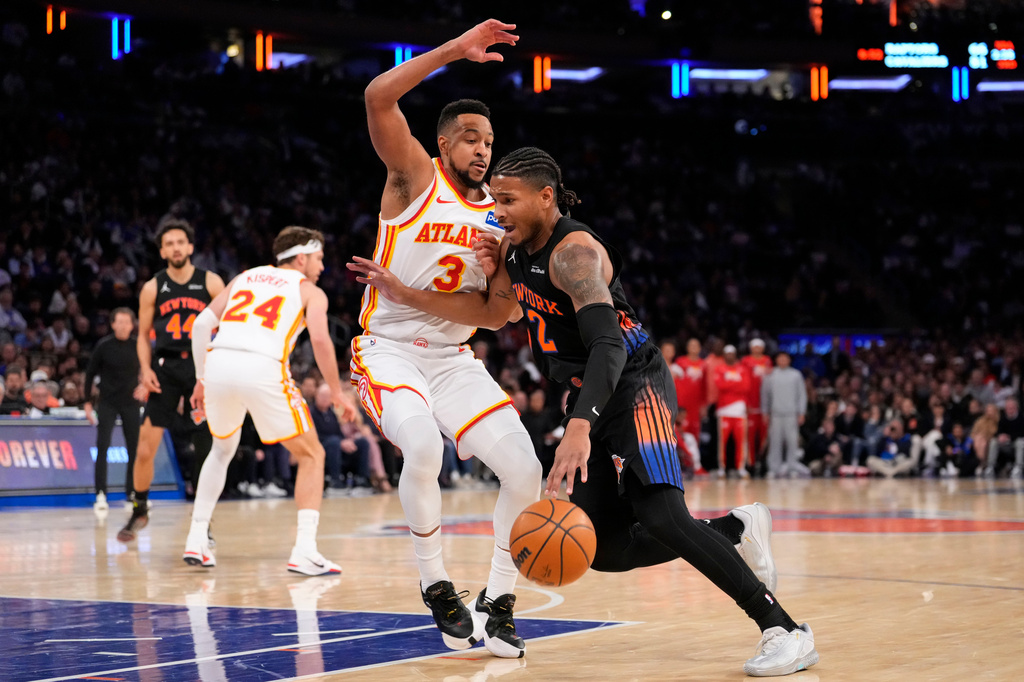 New York Knicks guard Miles McBride (2) drives past Atlanta Hawks guard CJ McCollum (3) during the first half in Game 2 of a first-round NBA playoffs basketball series, Monday, April 20, 2026, in New York. (AP Photo/Yuki Iwamura)