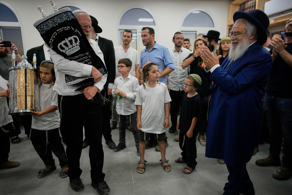 Israeli settlers celebrate the inauguration of a newly built synagogue at the occupied West Bank outpost of Homesh, Wednesday, Sept. 16, 2026. (AP Photo/Ohad Zwigenberg)