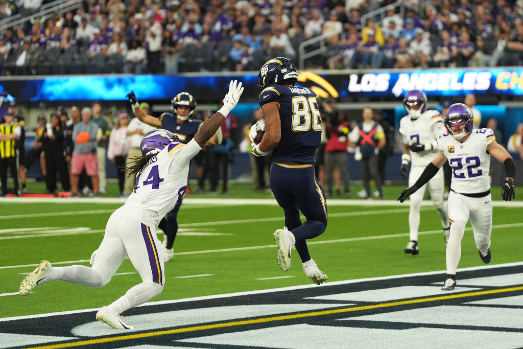 Los Angeles Chargers tight end Oronde Gadsden II (86) catches a touchdown pass ahead of Minnesota Vikings safety Josh Metellus (44) during the first half of an NFL football game Thursday, Oct. 23, 2025, in Inglewood, Calif. (AP Photo/Gregory Bull)