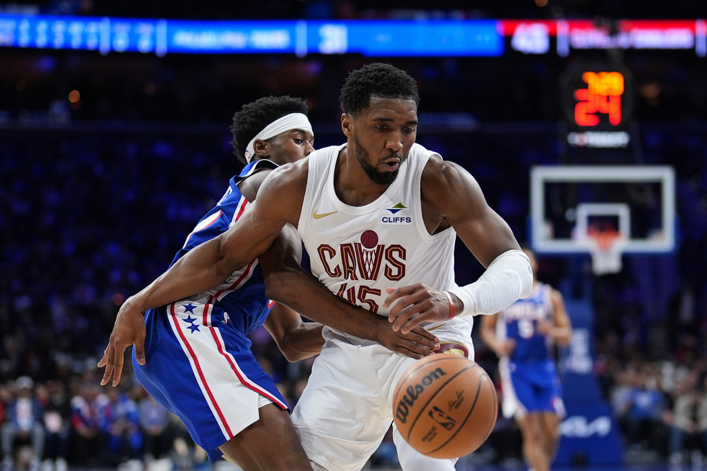 Cleveland Cavaliers' Donovan Mitchell, right, battles for the ball against Philadelphia 76ers' Vj Edgecombe during the first half of an NBA basketball game Wednesday, Jan. 14, 2026, in Philadelphia. (AP Photo/Matt Slocum)