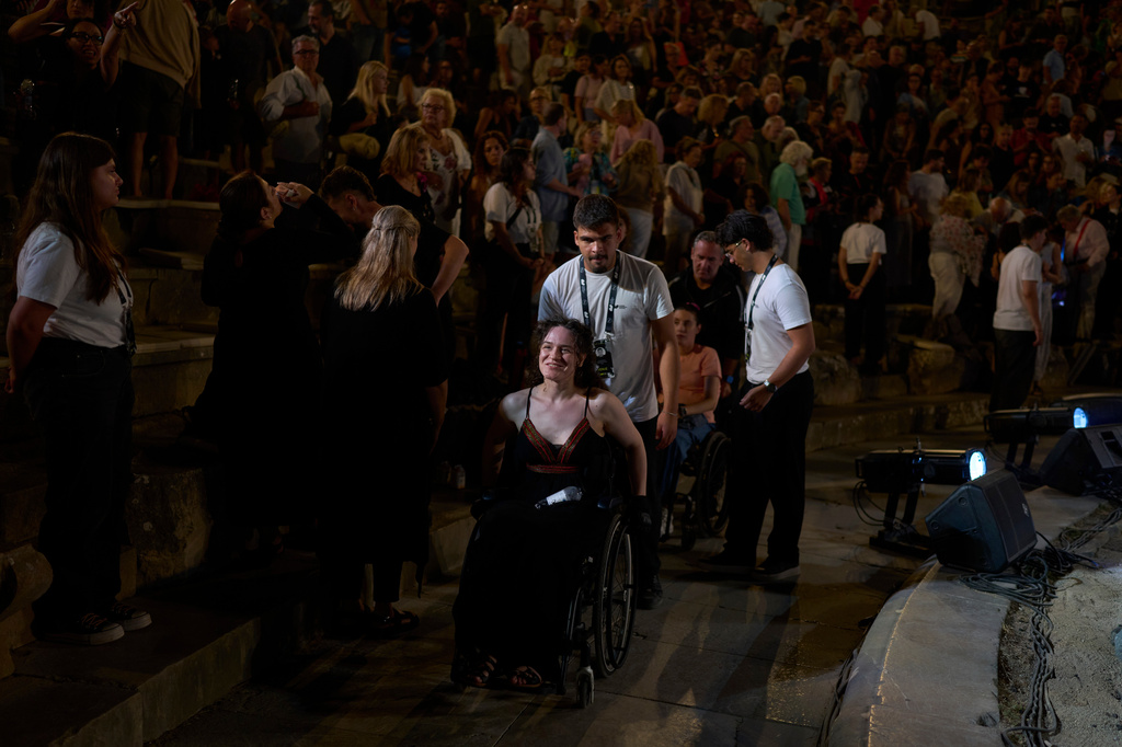 Oltjana Zoupas, an artist who uses a wheelchair, leaves the Ancient Theater of Epidaurus after attending a performance of Euripides' tragedy The Trojan Women, staged by the National Theatre of Greece, in Epidaurus, Greece, on Sunday, Aug. 2, 2026. (AP Photo/Petros Giannakouris)