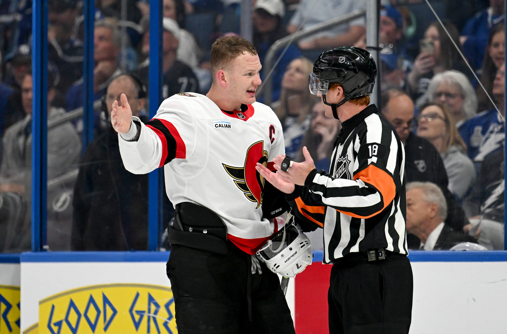 FILE - Ottawa Senators left wing Brady Tkachuk (7) talks to referee Tom Chmielewski (18) during the second period of an NHL hockey game against the Tampa Bay Lightning, March 28, 2026, in Tampa, Fla. (AP Photo/Jason Behnken, File)