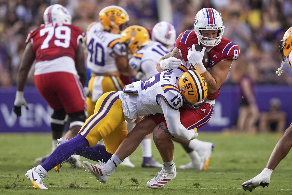 Louisiana Tech tight end Eli Finley (84) is tackled by LSU safety A.J. Haulcy (13) in the first half of an NCAA college football game Saturday, Sept. 6, 2025, in Baton Rouge, La. (AP Photo/Gerald Herbert)