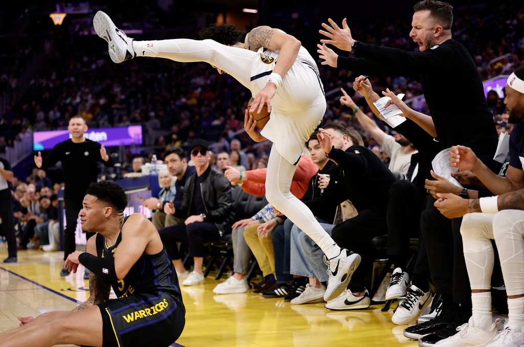 Denver Nuggets guard Julian Strawther, center, loses the ball out of bounds against Golden State Warriors guard Will Richard, left, during the first half of an NBA basketball game, Sunday, Feb. 22, 2026, in San Francisco. (AP Photo/Kelley L Cox)