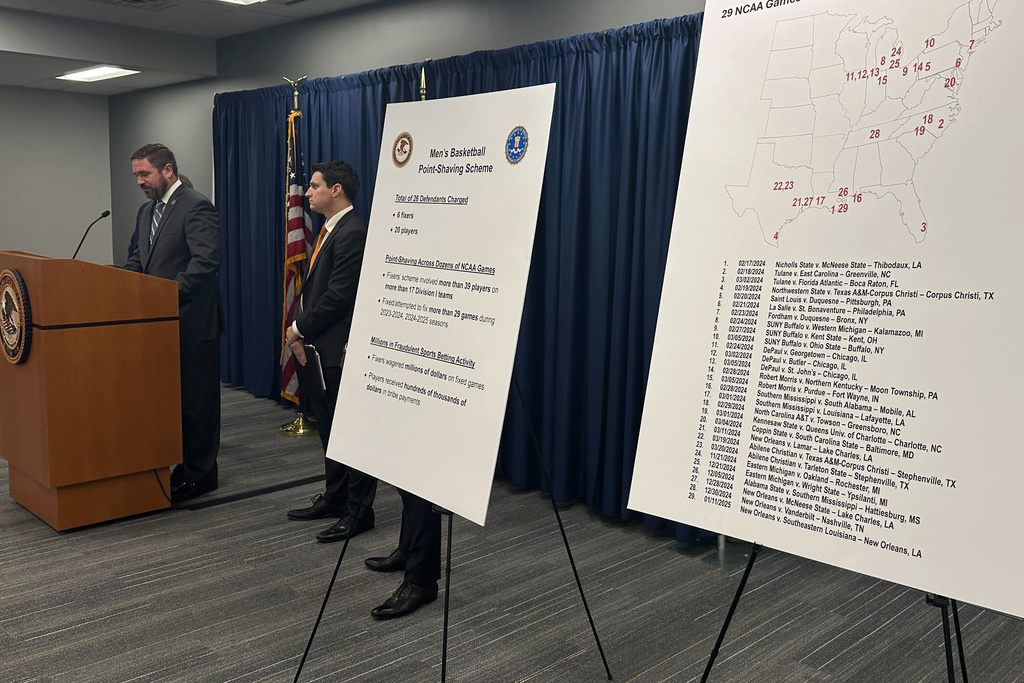 Information is displayed during a news conference to announce charges against 20 people including 15 former college basketball players, in what prosecutors called a betting scheme to rig NCAA and Chinese Basketball Association games, Thursday, Jan. 15, 2026 in Philadelphia. (AP Photo/Tassanee Vejpongsa)